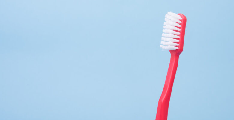 red toothbrush with blue background